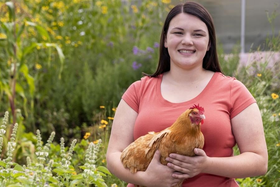 Interlochen Arts Academy student holds a chicken at the Botanical Lab