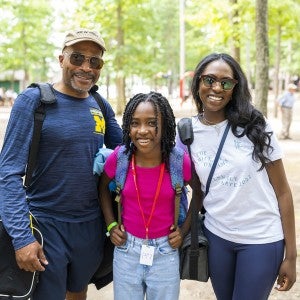 A young Camp student poses with parents.