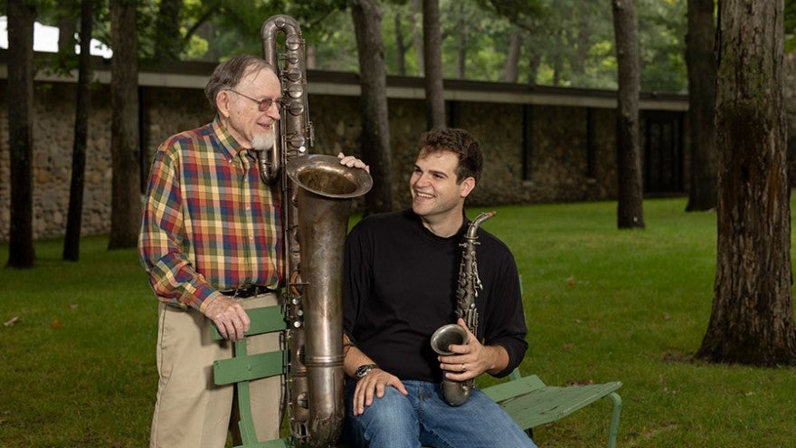Jake Goldwasser and John Beery pose with two vintage saxophones.