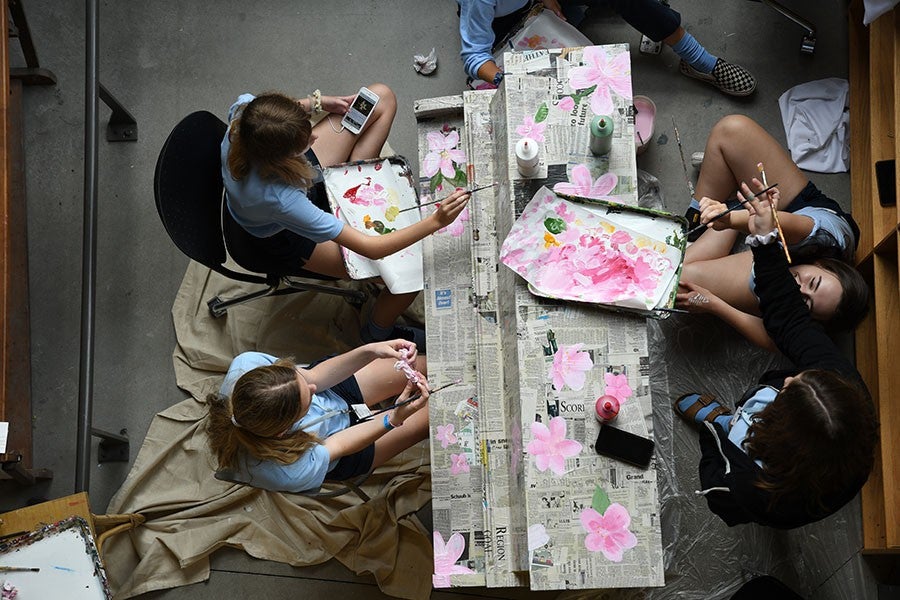 Students painting a piano
