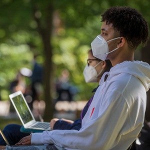 Students attend classes outdoors while wearing masks