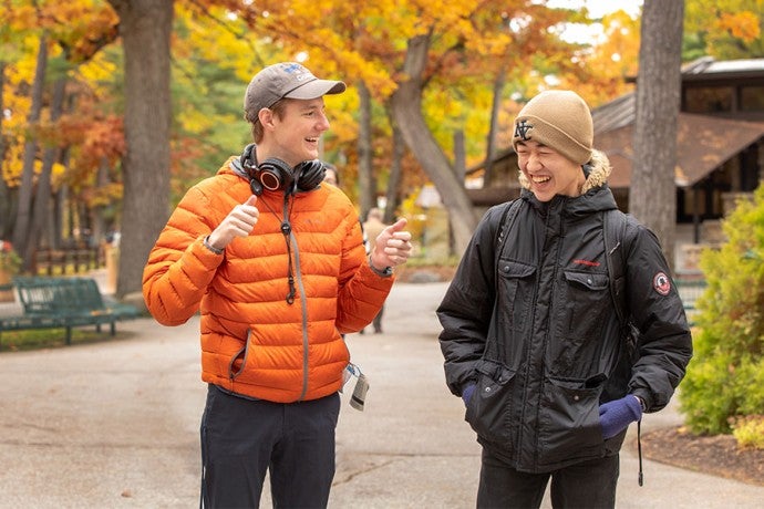 Two Interlochen Arts Academy share a laugh while walking on Osterlin Mall.
