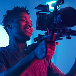 A student operates a video camera.