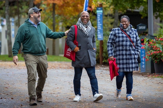 Three alumni stroll on campus during the Fall 2022 Interlochen Arts Academy Reunion.