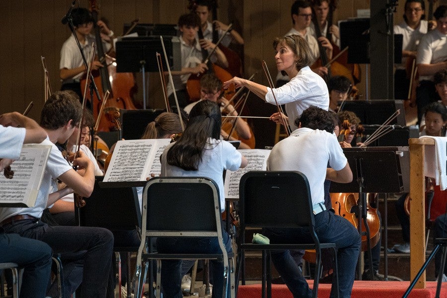 A conductor works with an orchestra of young students.