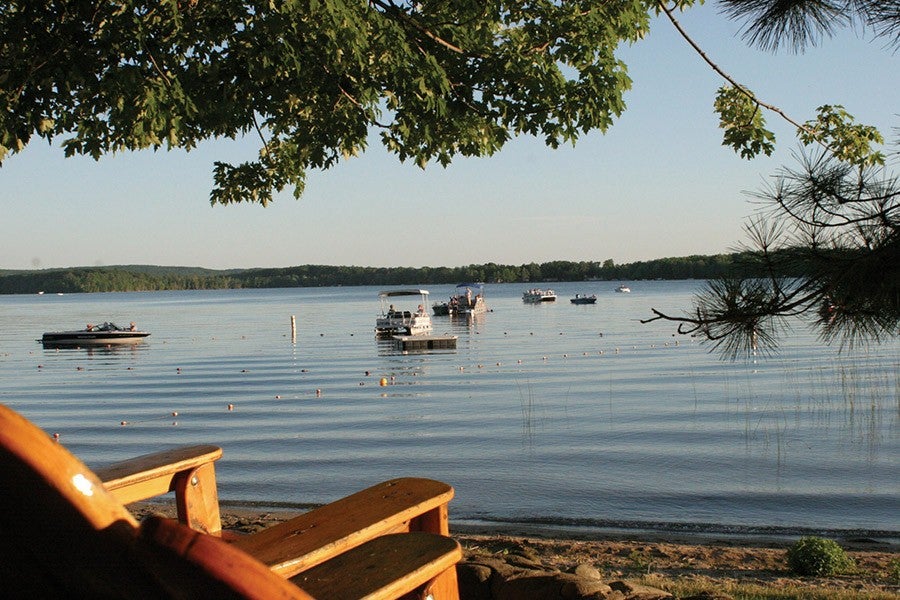 Several boats float on a gently rippling lake