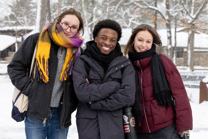 Three Interlochen Arts Academy students pause for a picture on a snowy day.