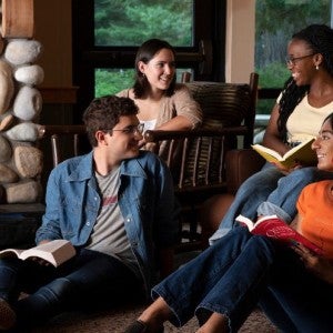 A group of students reading by a fireplace