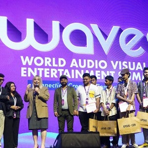 Briana Yarhouse (fourth from left, tan blazer) on the stage at a WAVES event.