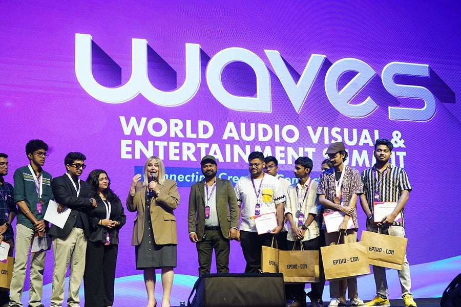 Briana Yarhouse (fourth from left, tan blazer) on the stage at a WAVES event.