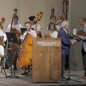 President of the American Classical Music Hall of Fame presents President Trey Devey with an induction medallion.